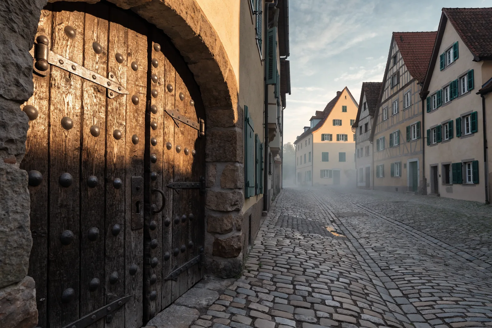 Symbolbild: historische Holztür mit altem Beschlag in einer Altstadtgasse – Einsatzgebiet Schlüsseldienst Wangen im Allgäu